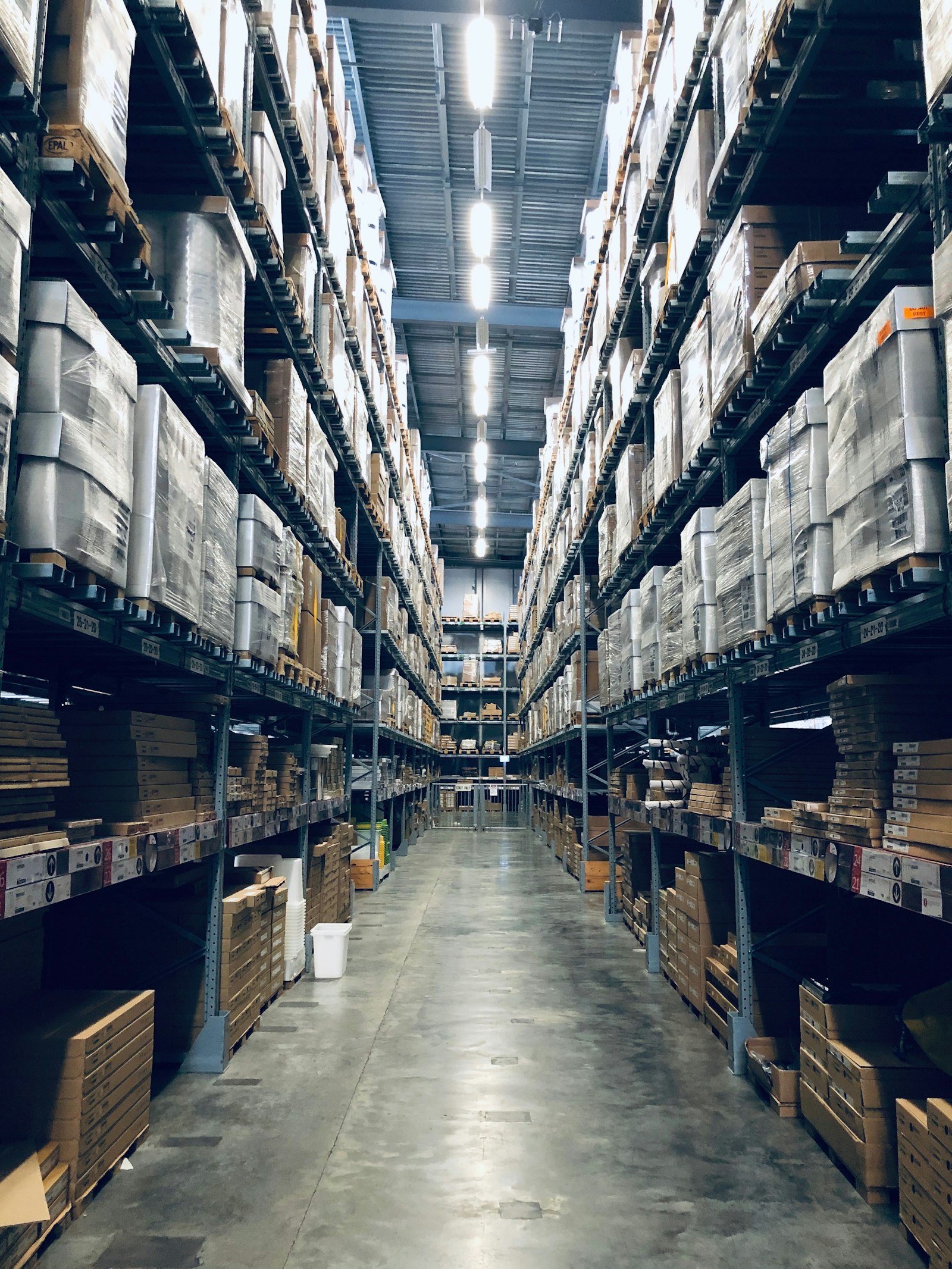 Aisle inside a deep warehouse with pallets